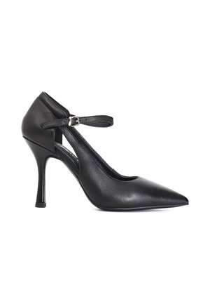 Sort læderstilet med spids tå, ankelrem og sølvspænde, slank stiletthæl, sideprofil på hvid baggrund.