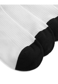 Fehér bordás zoknik fekete orr résszel, sima textúrával és klasszikus dizájnnal. Három pár szorosan egymás mellett.