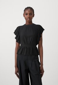 Čierny peplum top s krátkymi volánovými rukávmi, textúrovanou látkou, okrúhlym výstrihom a čipkovými detailmi na páse. Skombinovaný s čiernymi nohavicami.