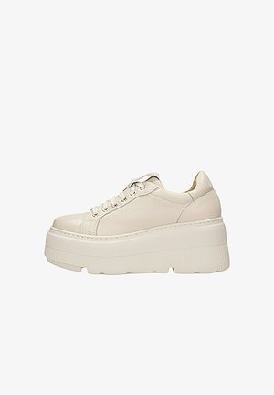 Baskets plateforme beige clair en cuir. Caractéristiques d'une semelle épaisse et striée avec un dessus lisse, un embout rond et un laçage à l'avant.