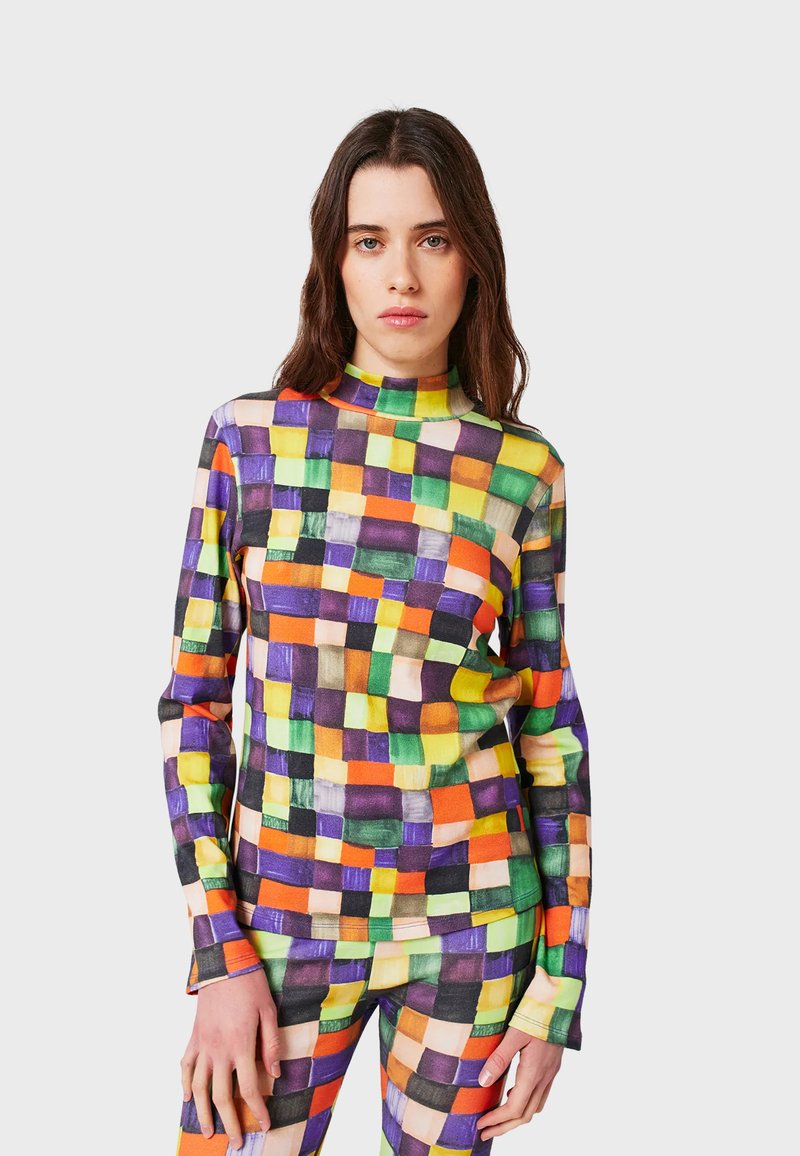 Long-sleeve top featuring a multicolored geometric pattern in purple, orange, green, and yellow. Made from a smooth, stretchy fabric.