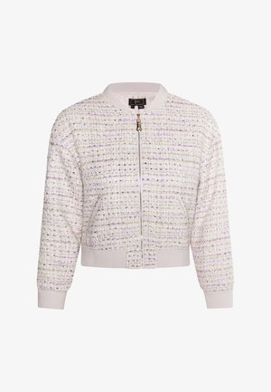 Akrós dzseki krém színű tweedből, lila és arany szálakkal. Elől cipzárral záródik, bordázott gallérral, és enyhén rugalmas mandzsettákkal és aljjal rendelkezik.