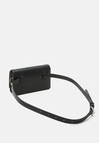 Černá kožená taška přes rameno obdélníkového tvaru s kontrastním prošíváním a nastavitelným popruhem s kovovými prvky a výřezovými akcenty.