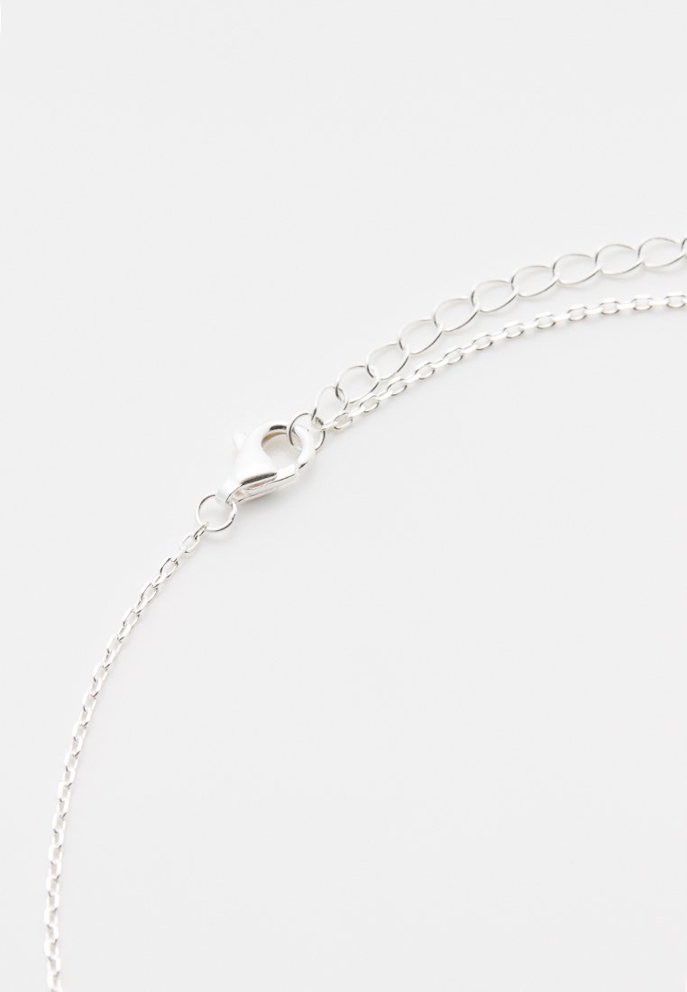 Collier en argent avec un fermoir à homard, présentant un design délicat et de petits maillons ovales. Texture lisse et finition brillante.