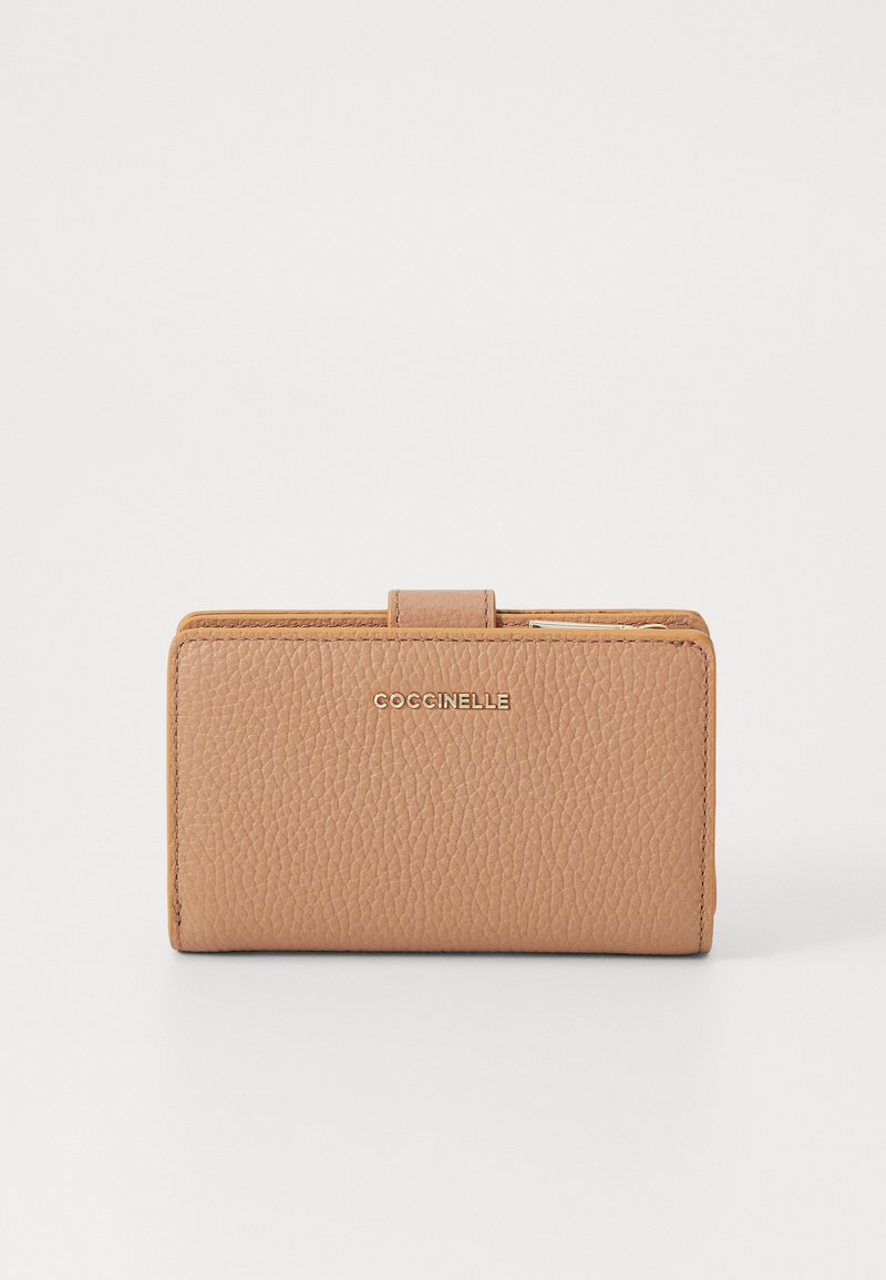 Portafoglio in pelle color tan con texture granulosa, dotato di chiusura a scatto e logo in tono oro. Forma rettangolare compatta con dettagli di cucitura visibili.
