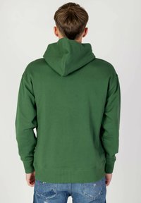 Felpa con cappuccio verde in misto cotone. Presenta polsini e orlo ribattuti, una texture liscia e una tasca a marsupio sul davanti.