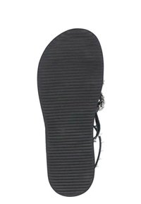 Sole in gomma nera con scanalature orizzontali per una migliore aderenza, con cinturini decorativi e accessori metallici sulla parte superiore.