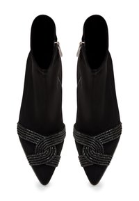 Bottines noires à bout pointu, avec une sangle décorative en perles sur le cou-de-pied et une finition mate lisse. Détail de fermeture éclair sur le côté.