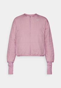 Lyserød cropped jakke med lynlås fortil, puffy tekstur, elastiske manchetter og et lille hvidt logo på øverste venstre side.