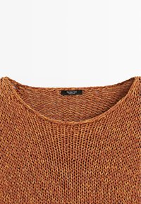 Pull marron en maille lâche avec un large col, montrant la texture et l'étiquette de la marque Massimo Dutti à l'intérieur du col.