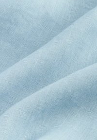 Tela azul clara con una superficie suave y ligeramente texturizada, que presenta un tejido fino y un brillo sutil, dispuesta en suaves pliegues.