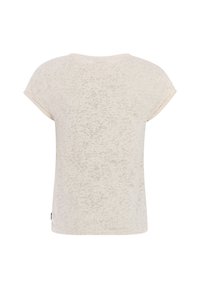 T-shirt beige clair à manches courtes avec un motif texturé subtil, col rond et une petite étiquette de marque sur le côté.