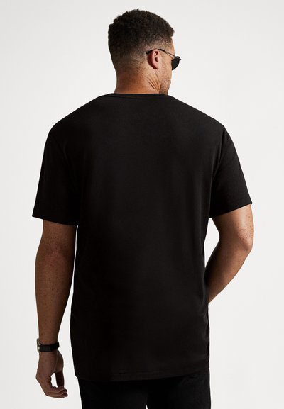 Svart t-shirt med korta ärmar, rund halsringning och ledig passform. Mjuk tyg med enfärgat mönster, sedd bakifrån.