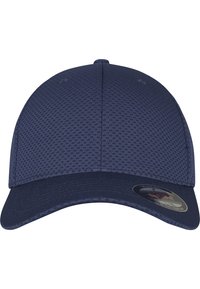 Navy blue cap with a textured mesh upper, solid visor, rounded crown, and a circular label on the side featuring a logo.
