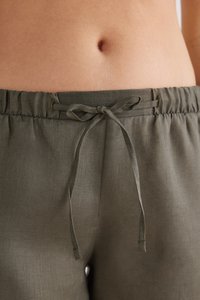 Kalhoty z lněné směsi v olivově zelené barvě s elastickým pasem na šňůrku. Materiál má hladkou texturu a volný střih, zahrnuje jemné detaily v švech.