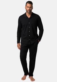 Black pajamas set for men with long sleeves and pants. Soft fabric, button-up shirt with pocket detail, fitted design.