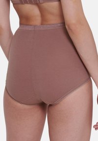 Culottes taille haute marron en tissu doux avec une texture lisse ; présentent des détails de couture délicats le long des bords.