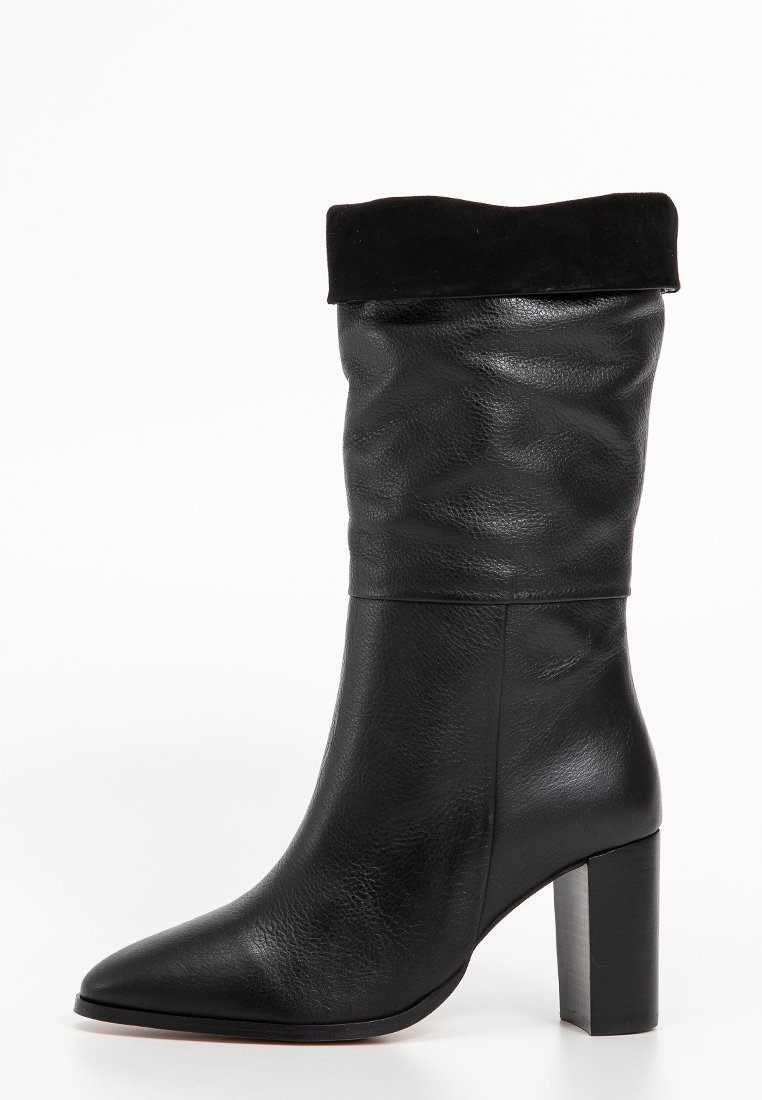 Bottine en cuir noir avec tige texturée, revers en suède noir doux, bout pointu et un grand talon épais. Fini lisse dans l'ensemble.