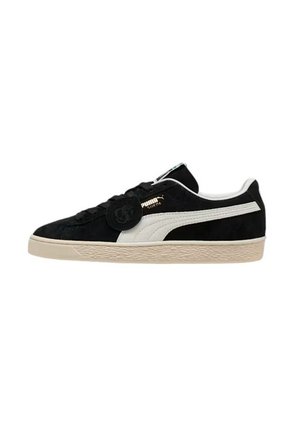 Sneaker Puma in suede nero con striscia bianca, suola beige e lacci neri, mostrato in profilo sinistro.