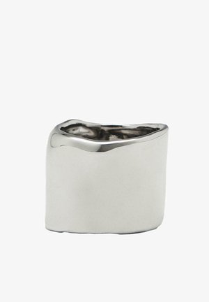 Anello spesso in argento con una superficie liscia e riflettente e un design con bordo ondulato, caratterizzato da una finitura lucida e una forma leggermente irregolare.