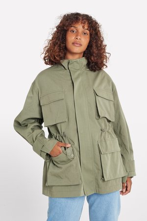 Veste olive avec un col haut, fermeture éclair sur le devant, plusieurs poches à rabat, taille cintrée et tissu léger. Design décontracté.