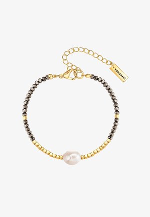 Rannekoru kultaisella sävyllä, jossa on pyöreitä mustia helmiä, kultaiset metallikoristeet, keskellä epäsäännöllinen valkoinen helmi ja lukko, jossa on merkki.