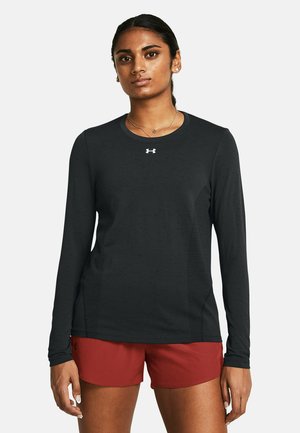 Black long-sleeve athletic shirt with a round neck and textured fabric. Features a small white logo on the chest, paired with red shorts.