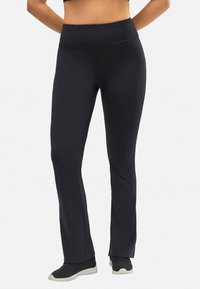 Pantalones de entrenamiento negros de campana con una cinturilla alta. Textura suave, tejido elástico y un ajuste cómodo. Adecuados para ropa activa.