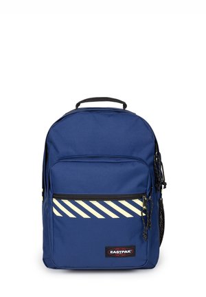 Blå Eastpak rygsæk med frontlynlåslomme, sort håndtag, reflekterende diagonale striber og net sidelomme på hvid baggrund.
