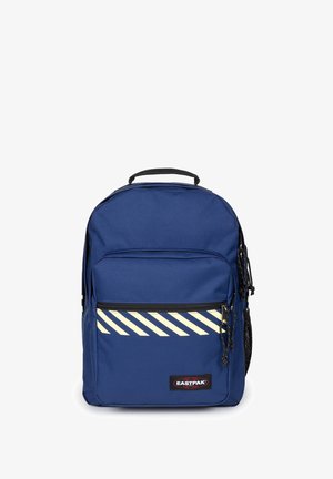 Blå Eastpak rygsæk med frontlynlåslomme, sort håndtag, reflekterende diagonale striber og net sidelomme på hvid baggrund.