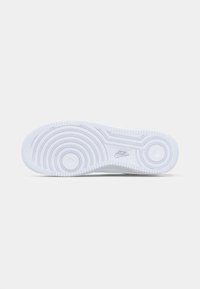 Bijela Nike tenisica s potplatom i kružnim uzorkom te Nike logom na središnjoj pozadini koja je također bijela.