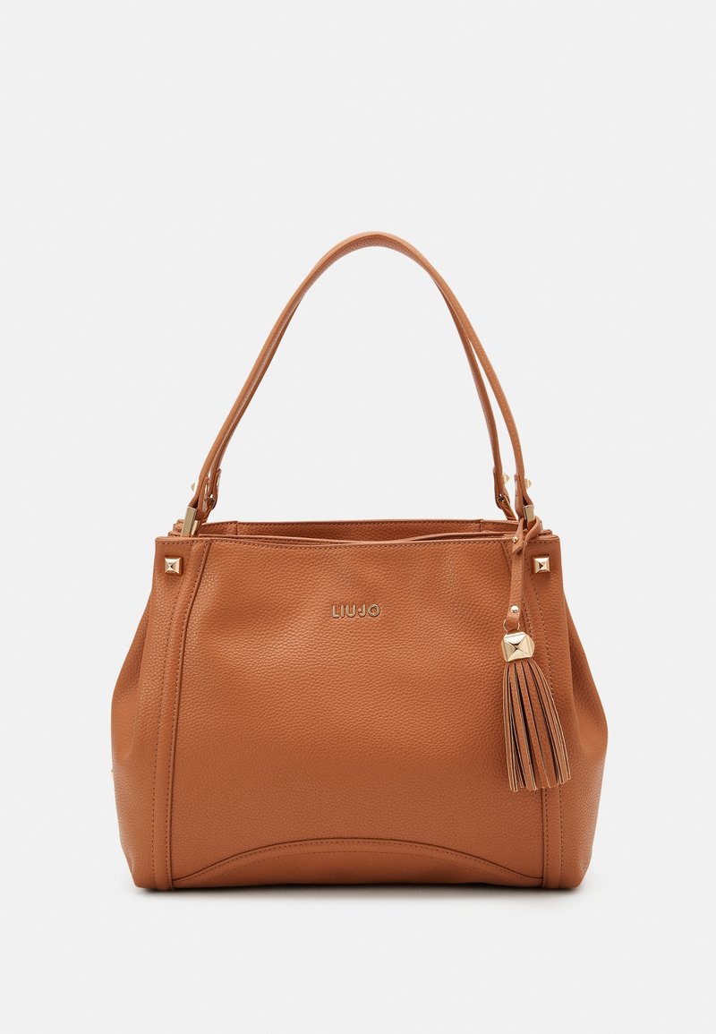 Sac à main en cuir marron texturé avec double sangle d'épaule, clous dorés, détail pompon et petit logo de la marque au centre avant.