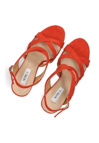 Rode suède hielsandalen met kruislings bandjes en een ronde open teen. Kenmerkt een beige binnenzool met een merklabel. Verstelbare enkelband.