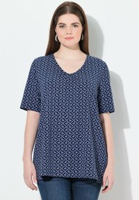 Námořnická modrá tričko s krátkým rukávem a výstřihem do V, s geometrickým vzorem v světlejší barvě. Měkká tkanina s uvolněným střihem.