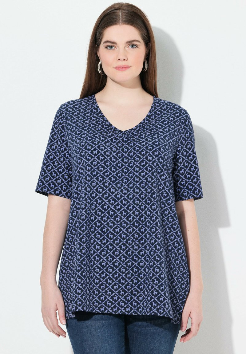 Námořnická modrá tričko s krátkým rukávem a výstřihem do V, s geometrickým vzorem v světlejší barvě. Měkká tkanina s uvolněným střihem.