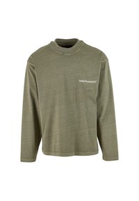 Olīvzaļš garas piedurknes kreklis ar apaļu kakla apkakli, uz kura kreisajā krūtī ir nelielā baltā fontā izdrukāts teksts "Svētdienas skriešanas klubs".