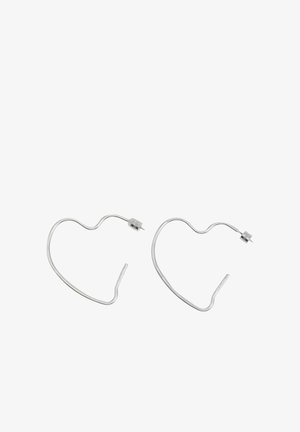 Coppia di orecchini a cerchio a forma di cuore in argento con chiusura a perno su sfondo bianco.