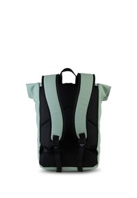 Vista trasera de una mochila ligera de color verde claro y negro, con correas de hombro acolchadas y un asa en la parte superior, sobre un fondo blanco.
