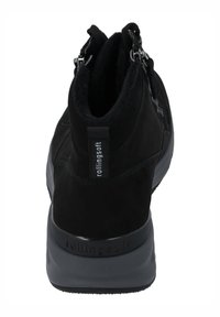 Botines de ante negro con un cuello acolchado, que presentan cremalleras laterales, una suela de goma texturizada y un sutil logo en el talón.