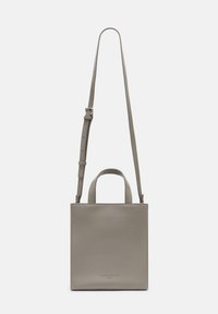 Kwadratowa szara skórzana torebka z dwoma krótkimi uchwytami i regulowanym paskiem na ramię. Gładka tekstura, minimalistyczny design, wytłoczone logo z przodu.