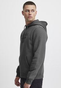 Dark gray hoodie with a kangaroo pocket, drawstring hood, and embossed text "NEW YORK" on the front. Soft, smooth fabric with a relaxed fit.