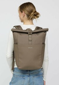 Brauner Roll-Top-Rucksack mit verstellbaren gepolsterten Trägern und einer Fronttasche. Hergestellt aus strapazierfähigem Material mit einer glatten Textur.