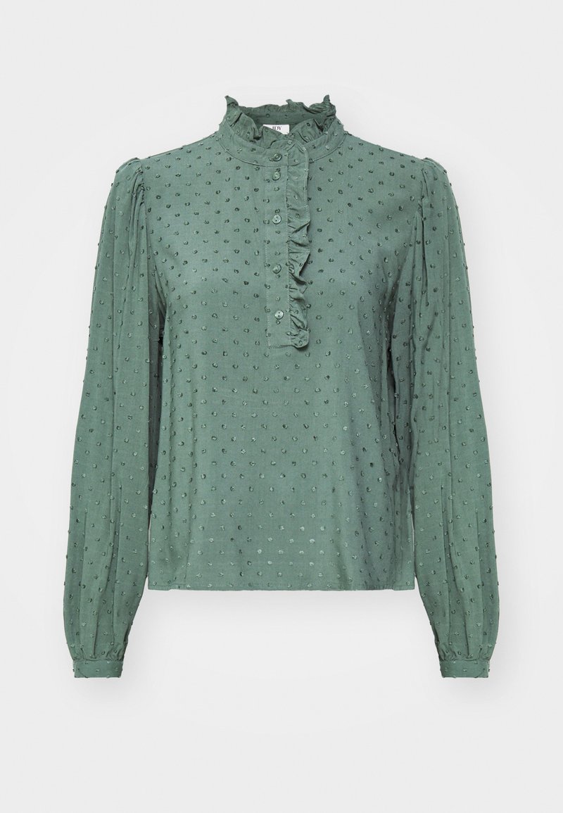 Groene blouse met lange mouwen, geraffineerde kraag en knopenlijst. De getextureerde stof heeft kleine gespreide stippen. Aansluitende manchetten aan de uiteinden van de mouwen.
