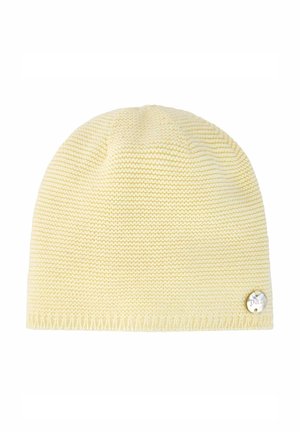 Bonnet en tricot jaune pâle doux avec un ourlet côtelé et une petite étiquette ronde en argent sur le bord inférieur.