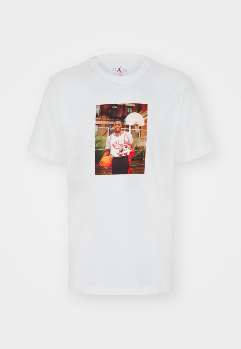 Biały bawełniany t-shirt z grafiką z przodu przedstawiającą koszykarza trzymającego piłkę, z czarnymi i czerwonymi akcentami w designie.