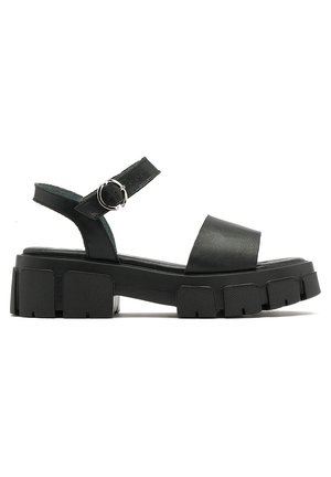 Black platform sandals with a wide front strap and adjustable ankle strap. Features a chunky textured sole for enhanced grip and stability.