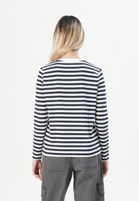 Langärmliges Shirt mit navyblauen und weißen horizontalen Streifen. Weicher Stoff mit Rundhalsausschnitt und lockerer Passform, die das Rückendesign betont.
