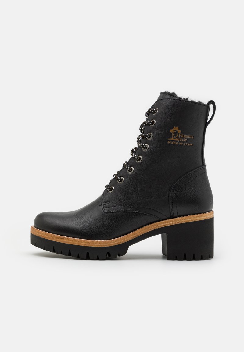 Czarny skórzany botek za kostkę z wiązaniami, masywnym obcasem i szorstką podeszwą. Posiada szczegóły z logo oraz kontrastującą brązową środkową podeszwę.