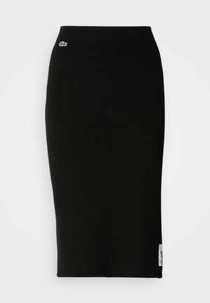 Black ribbed knit midi skirt featuring a fitted silhouette. Small Lacoste logo detail on the waistband, with a smooth texture.