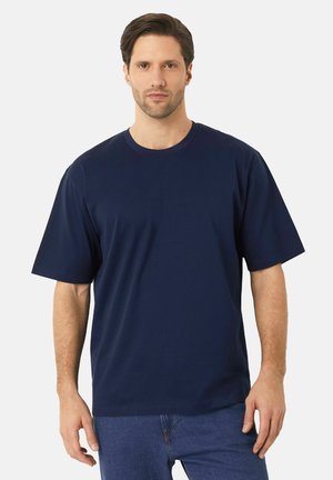 Marineblå kortærmet T-shirt med rund hals lavet af glat bomuld, med en løs pasform og minimale designkomponenter.